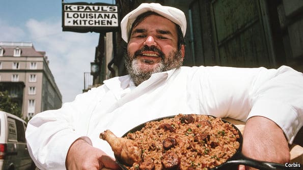 Chef Paul Prudhomme outside of K-Paul's restaurant in New Orleans holding a plate of jambalaya