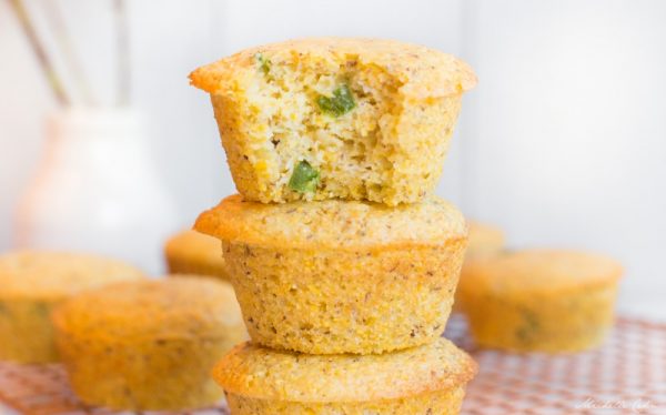 Stack of cornbread muffins with a bite taken out of one.