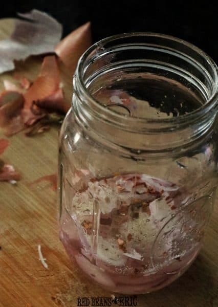 Mason jar of sliced shallots in vinegar with spices.